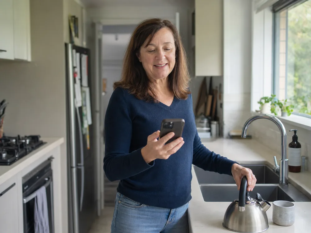 Vendor reading a follow-up message on her phone moments after enquiring